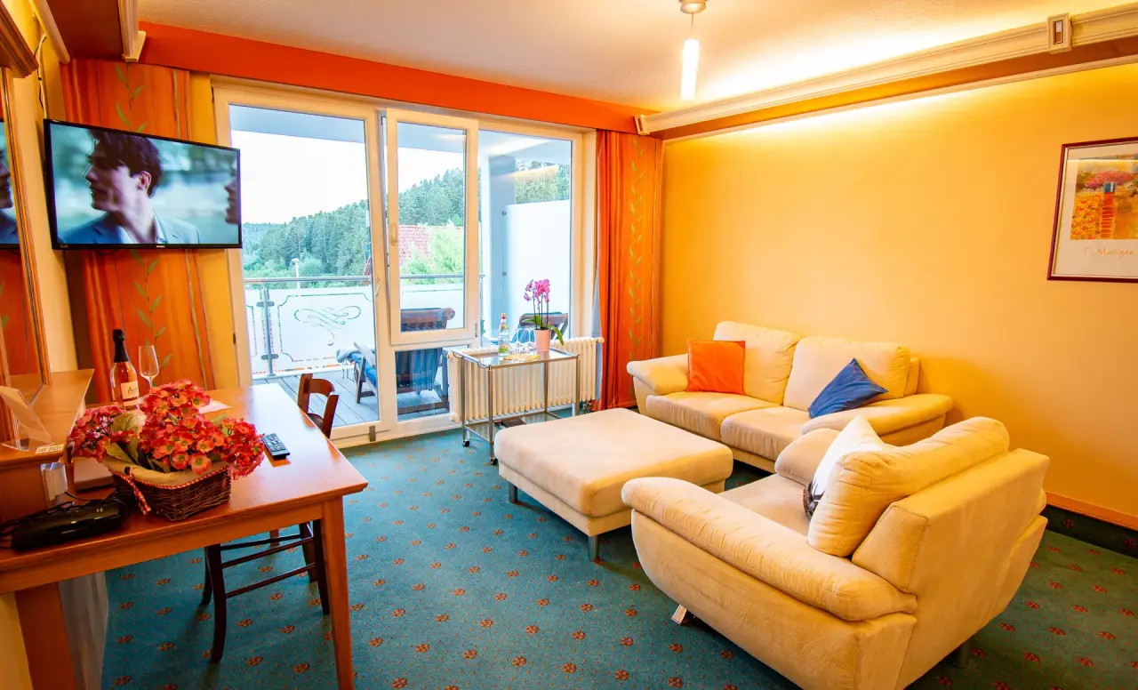 Geräumiges Hotelzimmer mit Wohnbereich, Balkon und Blick ins Grüne im Vital- und Wellnesshotel Albblick.