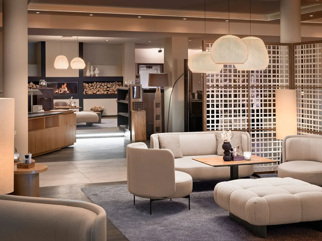 Gemütliche Lobby mit modernem Design und Kamin im Panoramahotel Oberjoch. Ideal zum Entspannen.