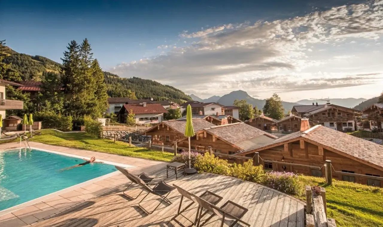 Panoramahotel Oberjoch: Grosser Aussenpool mit Bergblick und Holzterrasse. Entspannung pur in der idyllischen Alpenlandschaft.