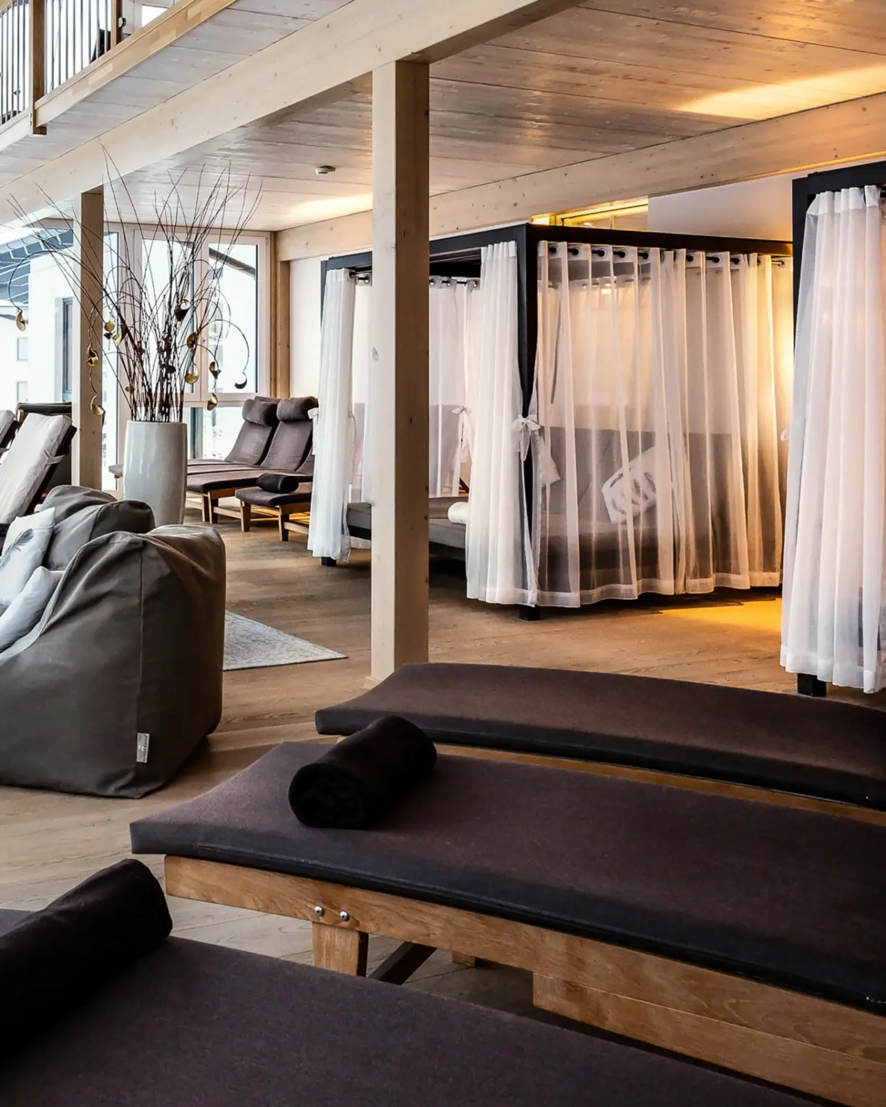 Gemütlicher Entspannungsbereich mit Holzdesign, bequemen Liegen und Daybeds im Spa des Panoramahotel Oberjoch.