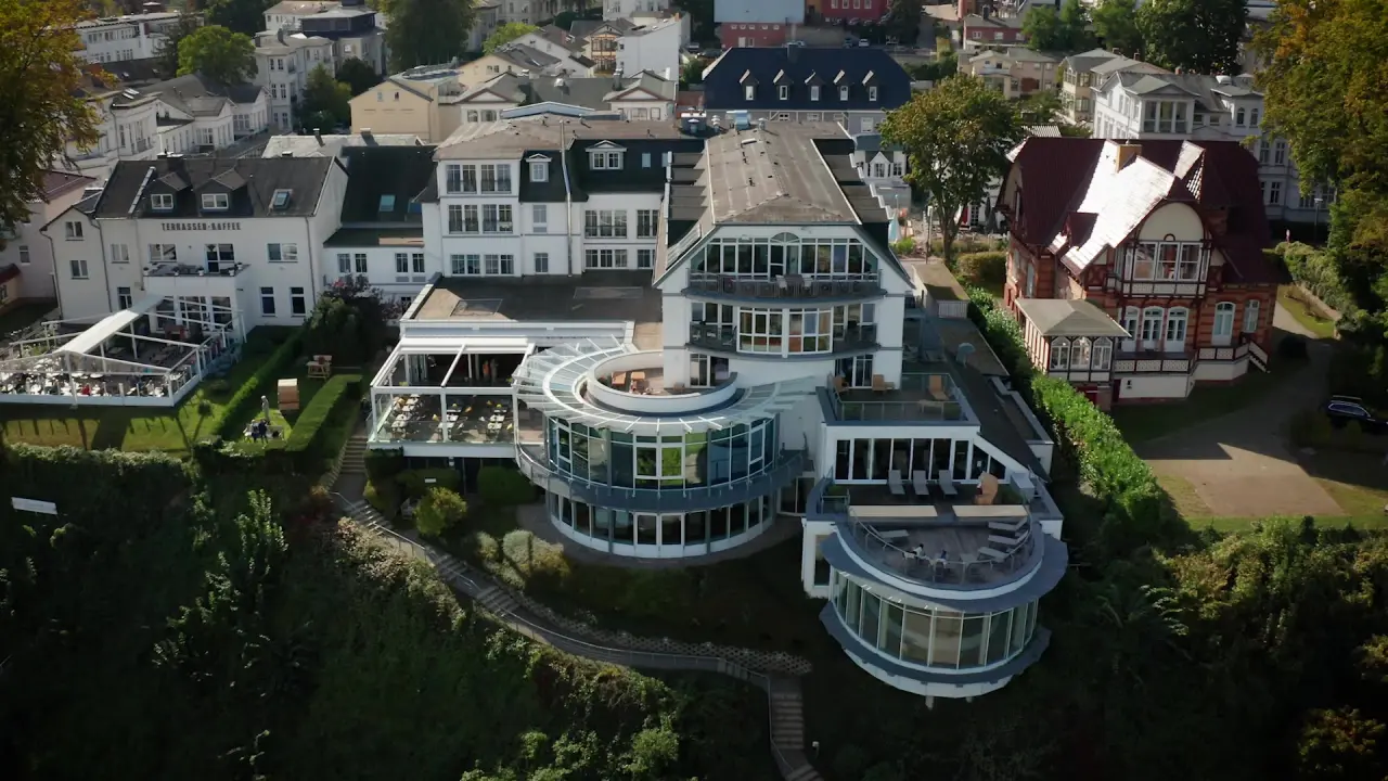 Luftaufnahme des Strandhotel Ostseeblick mit Terrassen, Balkonen und umliegender Bebauung an der Ostseeküste.