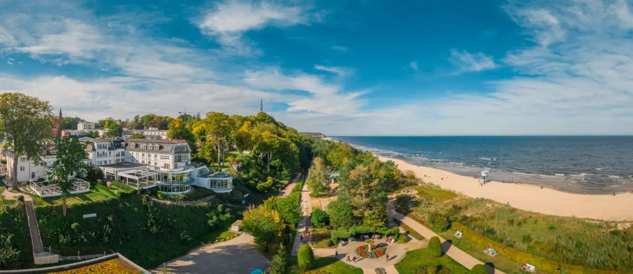 Panorama-Aussenansicht des Strandhotel Ostseeblick mit direktem Blick auf den breiten Sandstrand und die Ostsee.