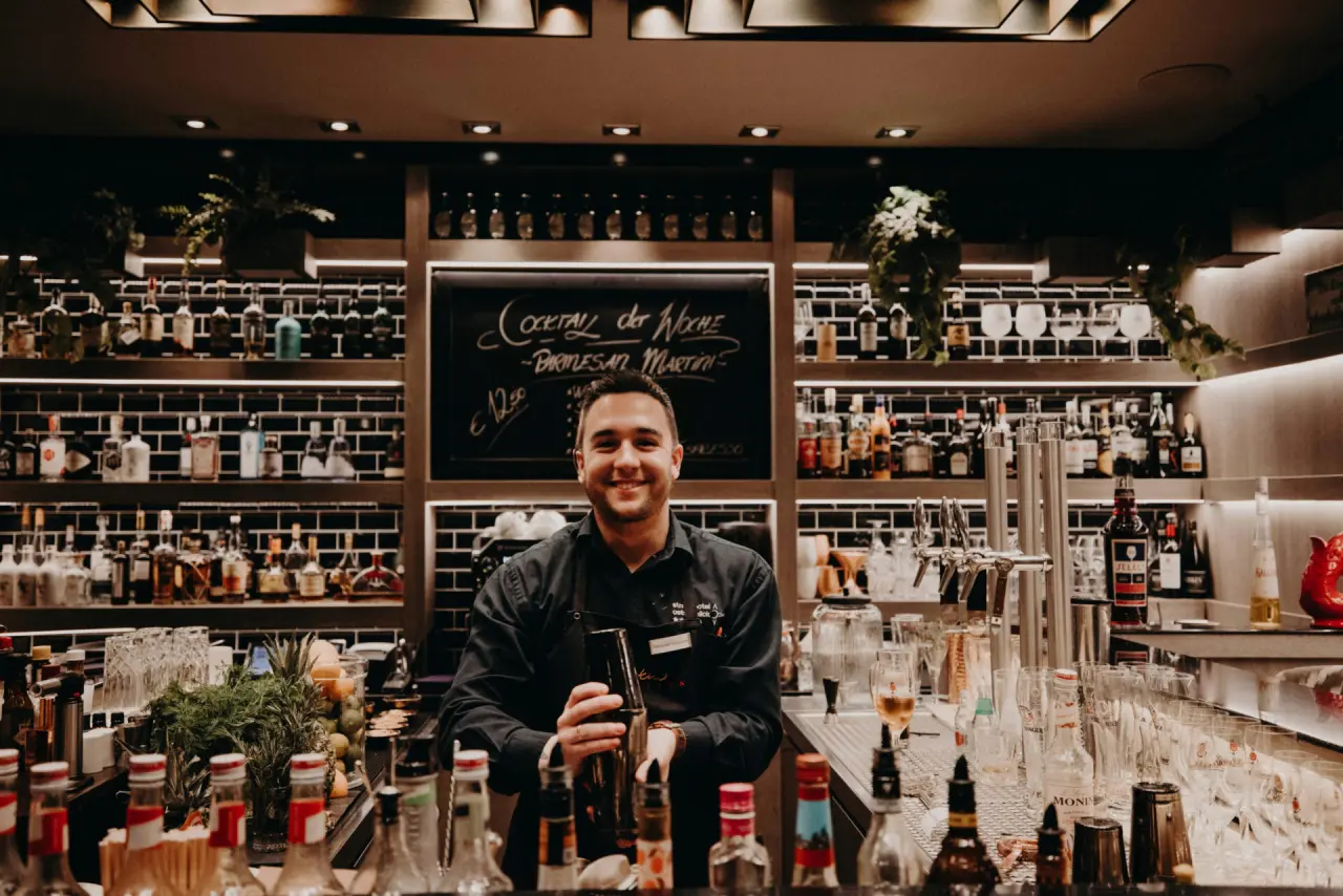 Freundlicher Barkeeper mixt Cocktails an der gut sortierten Bar im Strandhotel Ostseeblick.