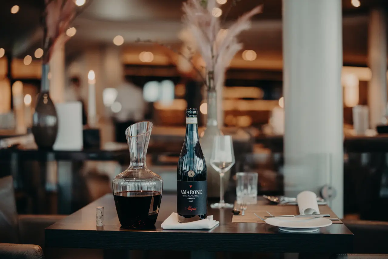 Elegante Weinflasche und Karaffe auf einem gedeckten Tisch im Restaurant des Strandhotel Ostseeblick.
