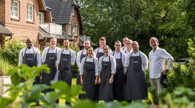 Das Küchenteam des Landhaus Stricker präsentiert sich vor dem charmanten Hotelgebäude im Grünen.
