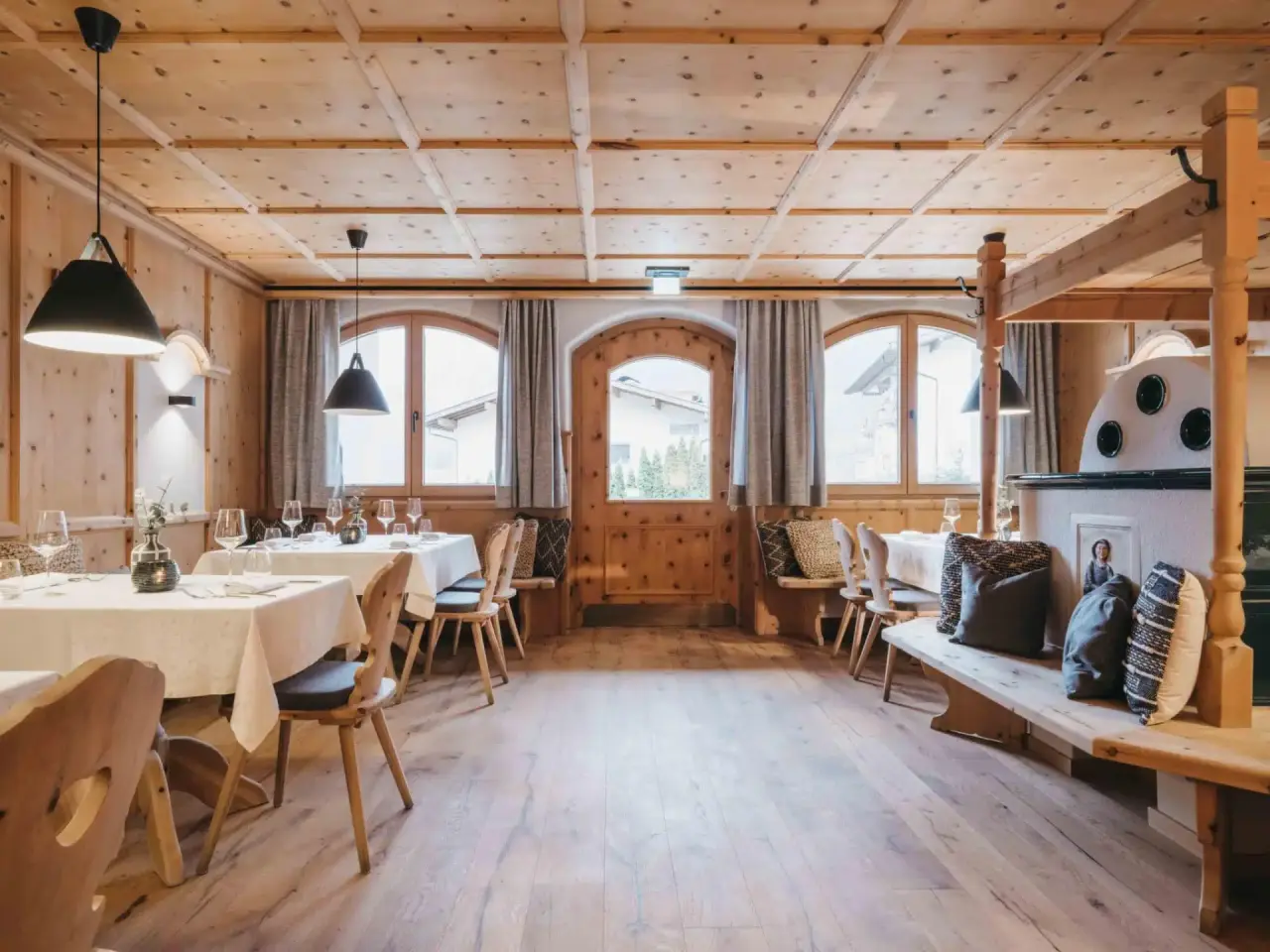 Gemütliches Restaurant im alpinen Stil mit Holzeinrichtung und gedeckten Tischen im VAYA Zillertal.