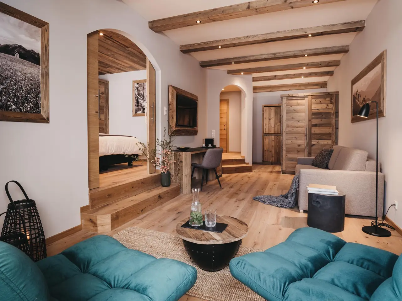 Geräumige Suite im VAYA Zillertal mit gemütlichem Wohnbereich, Holzbalken und separatem Schlafzimmer.