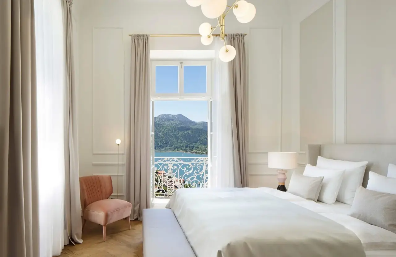 Luxuriöses Hotelzimmer im DAS TEGERNSEE mit Balkon und atemberaubendem Blick auf den Tegernsee und die Berge.