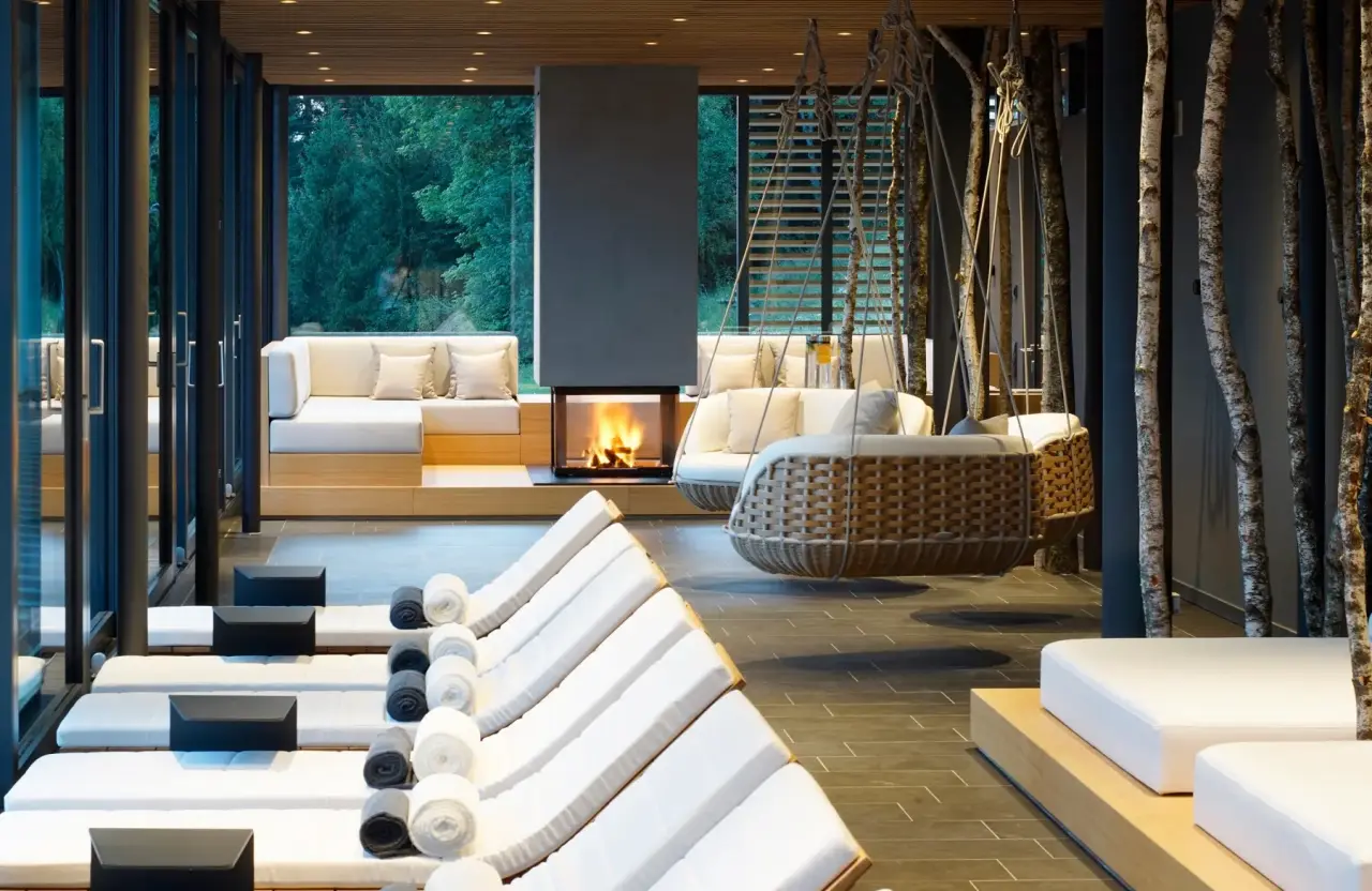 Exklusiver Spa-Ruheraum mit Kamin, Designer-Liegen und Hängesesseln sowie Waldblick im Hotel DAS TEGERNSEE.