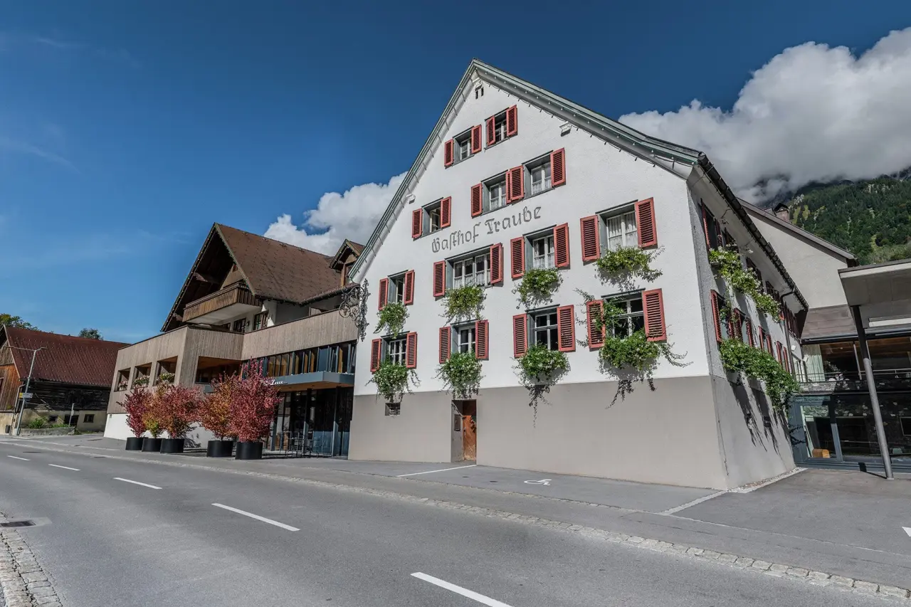 Aussenansicht des TRAUBE BRAZ Alpen.Spa.Golf.Hotel mit traditionellem Gasthof und modernem Anbau in den Alpen.