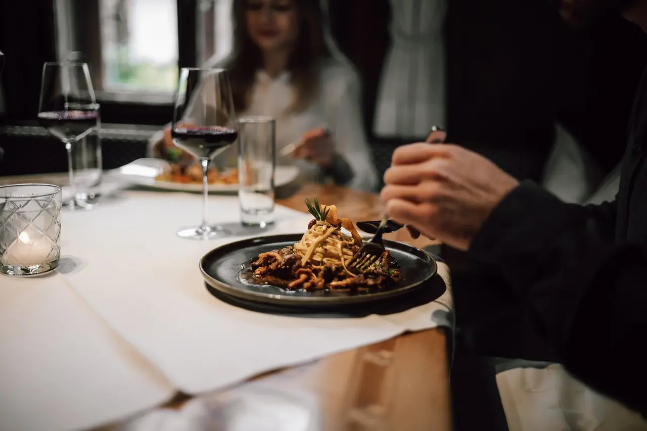 Abendessen mit Pasta und Rotwein im Restaurant des TRAUBE BRAZ Alpen.Spa.Golf.Hotel.