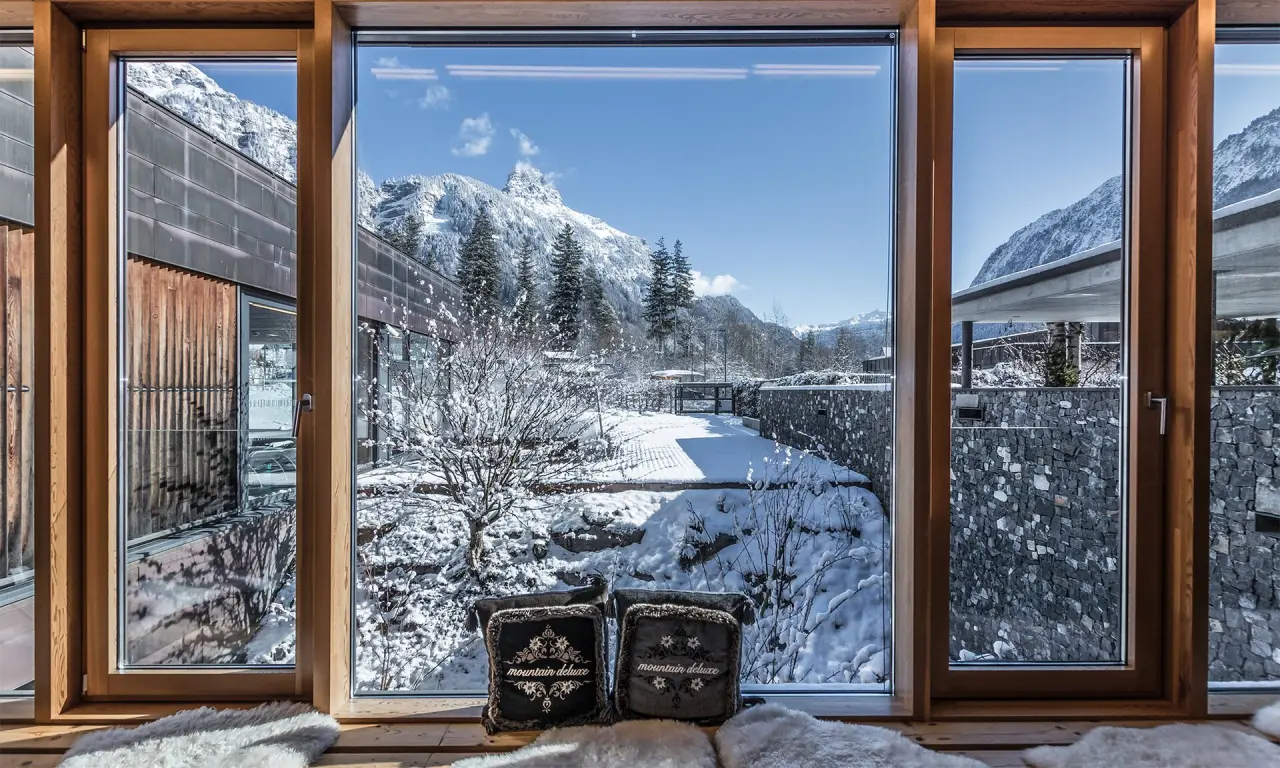 Gemütlicher Ausblick aus einem Hotelzimmer des TRAUBE BRAZ Alpen.Spa.Golf.Hotel auf verschneite Berge und Winterlandschaft.