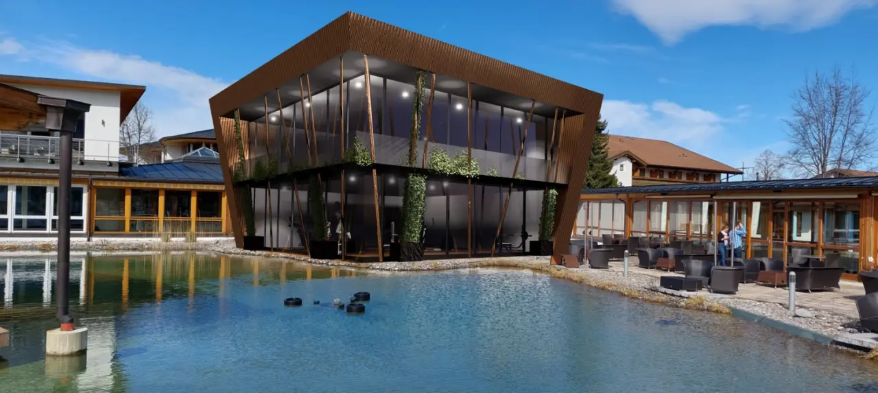 Modernes Fitness- und Wellnessgebäude am Naturteich des König Ludwig Inspiration SPA mit Außenterrasse.