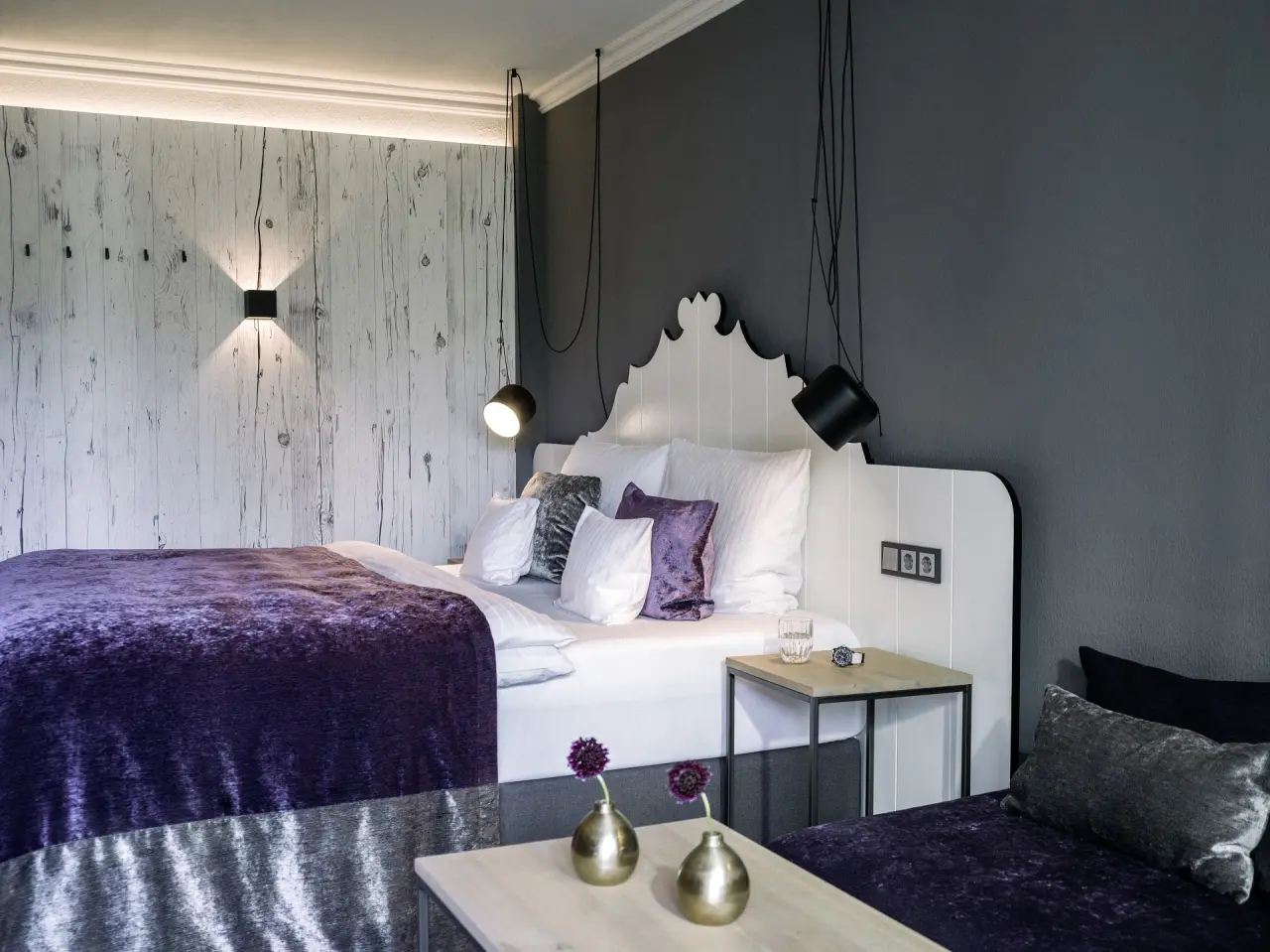Modernes Doppelzimmer mit lila Akzenten und Holzwand im König Ludwig Inspiration SPA