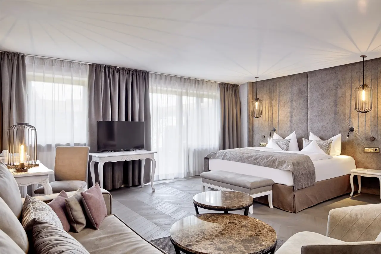 Elegantes Doppelzimmer mit großem Bett, Sofa und stilvoller Einrichtung im Das König Ludwig Inspiration SPA.