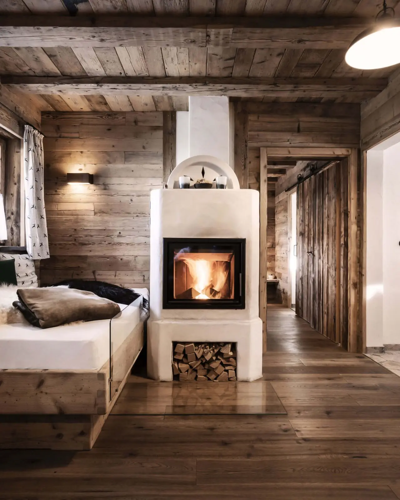 Alpin Chalets Oberjoch: Gemütliches Chalet-Zimmer mit knisterndem Kamin und rustikalen Holzelementen für entspannte Abende.