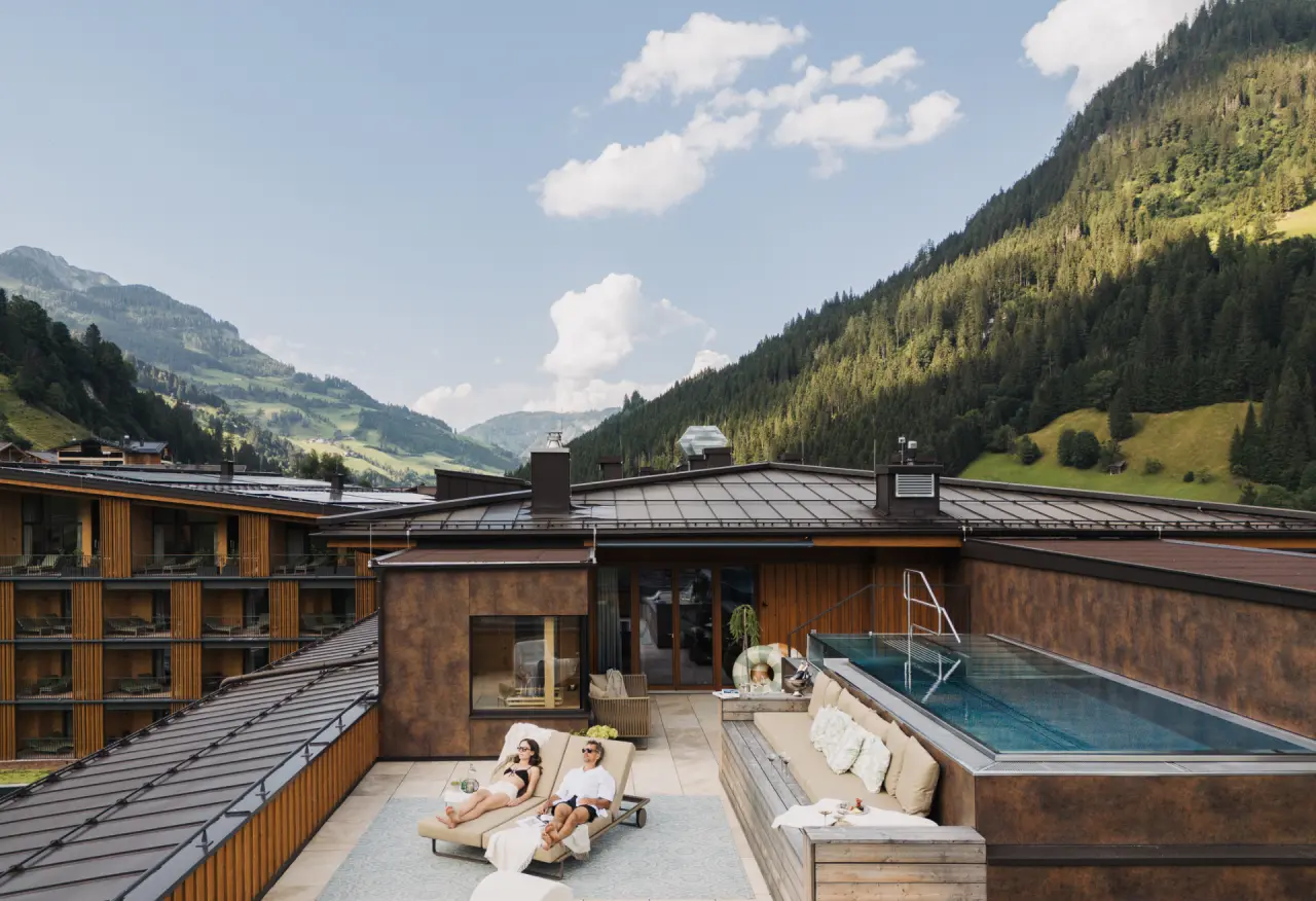 Dachterrasse mit Infinity Pool, Sonnenliegen und Alpenpanorama im Hotel Nesslerhof.