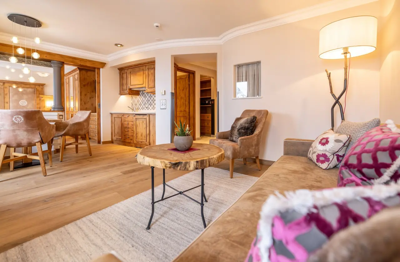 Gemütlicher Wohnbereich einer Suite mit Holzküche und bequemen Möbeln im BelArosa Hotel.