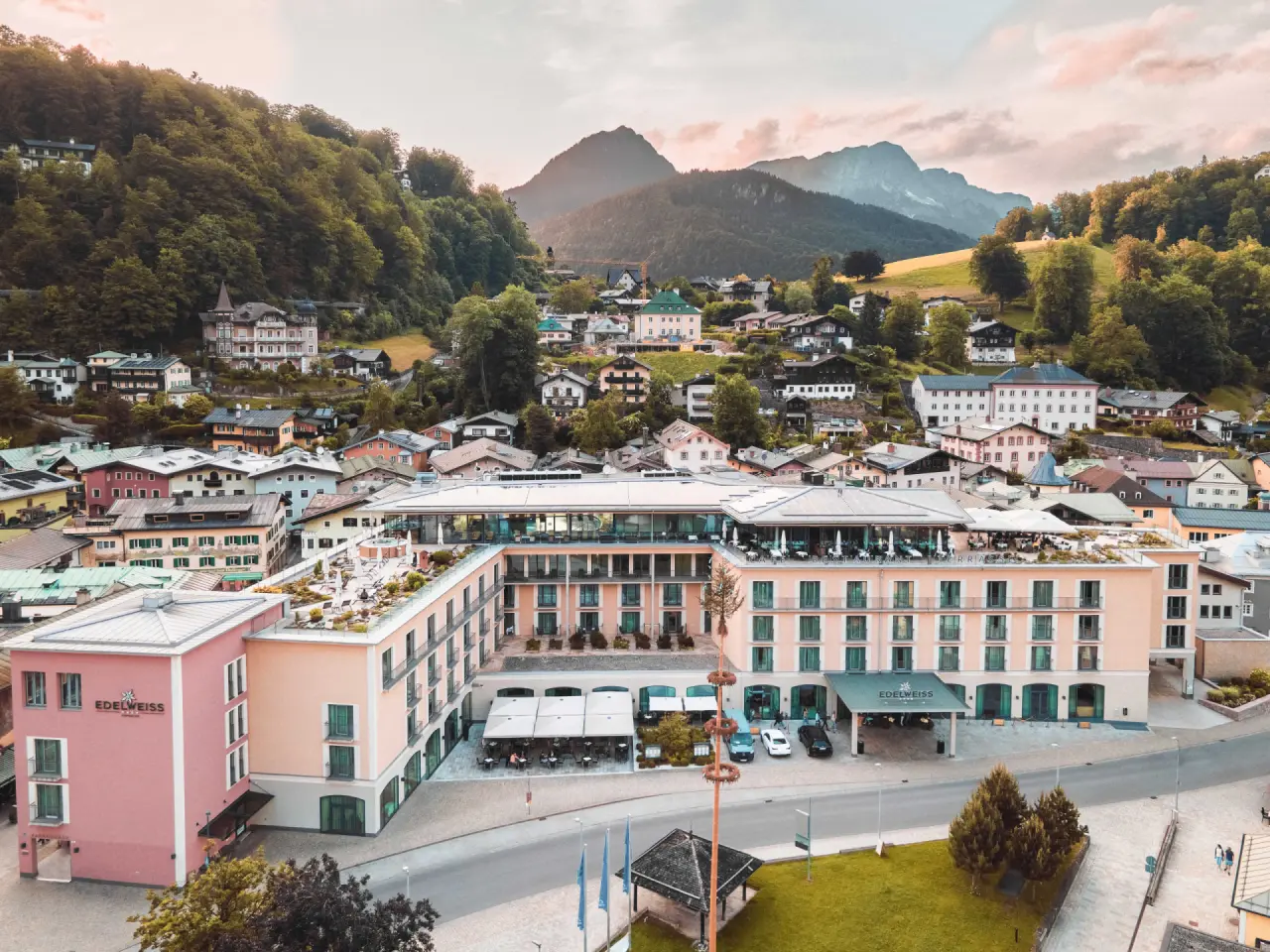 Luftaufnahme des Hotel EDELWEISS Berchtesgaden mit Alpenpanorama und der malerischen Stadtkulisse im Hintergrund.