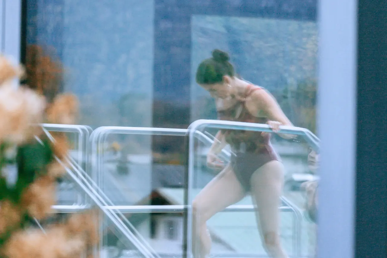 Gast steigt über eine Treppe in den Innenpool des Hotel EDELWEISS Berchtesgaden für entspannende Momente.