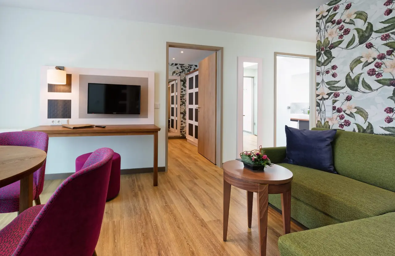 Gemütliches Hotelzimmer im Ringhotel Sellhorn mit Sofa, Sessel und TV-Bereich.