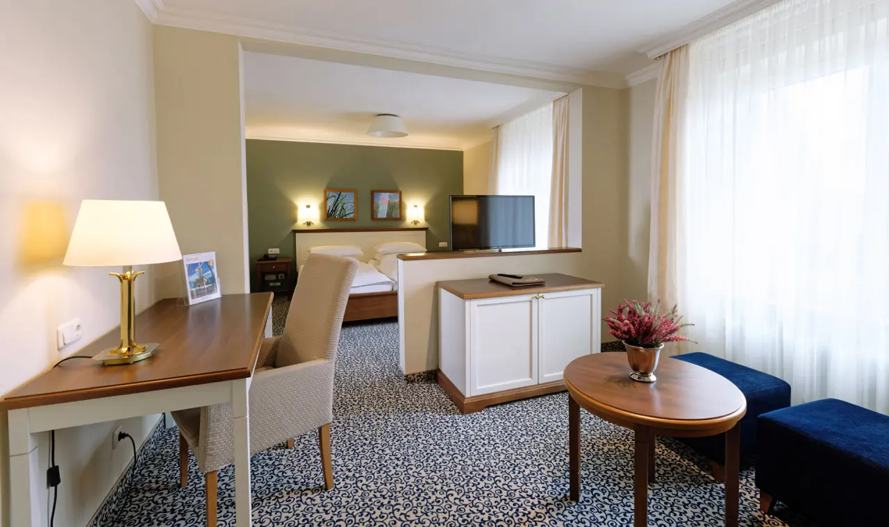 Geräumiges Hotelzimmer mit Doppelbett, Schreibtisch und Sitzbereich im Ringhotel Sellhorn.