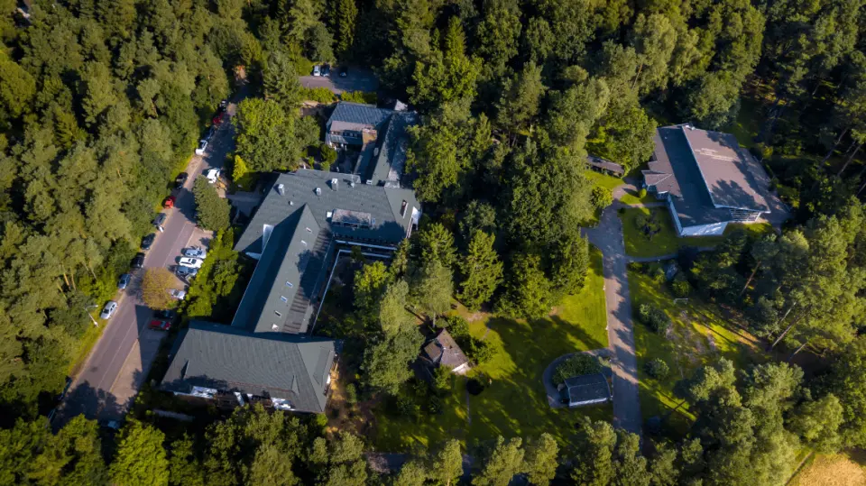 Luftaufnahme des Hotel Zur Heidschnucke, eingebettet in einen dichten Wald. Zeigt die weitläufige Anlage in ruhiger Natur.