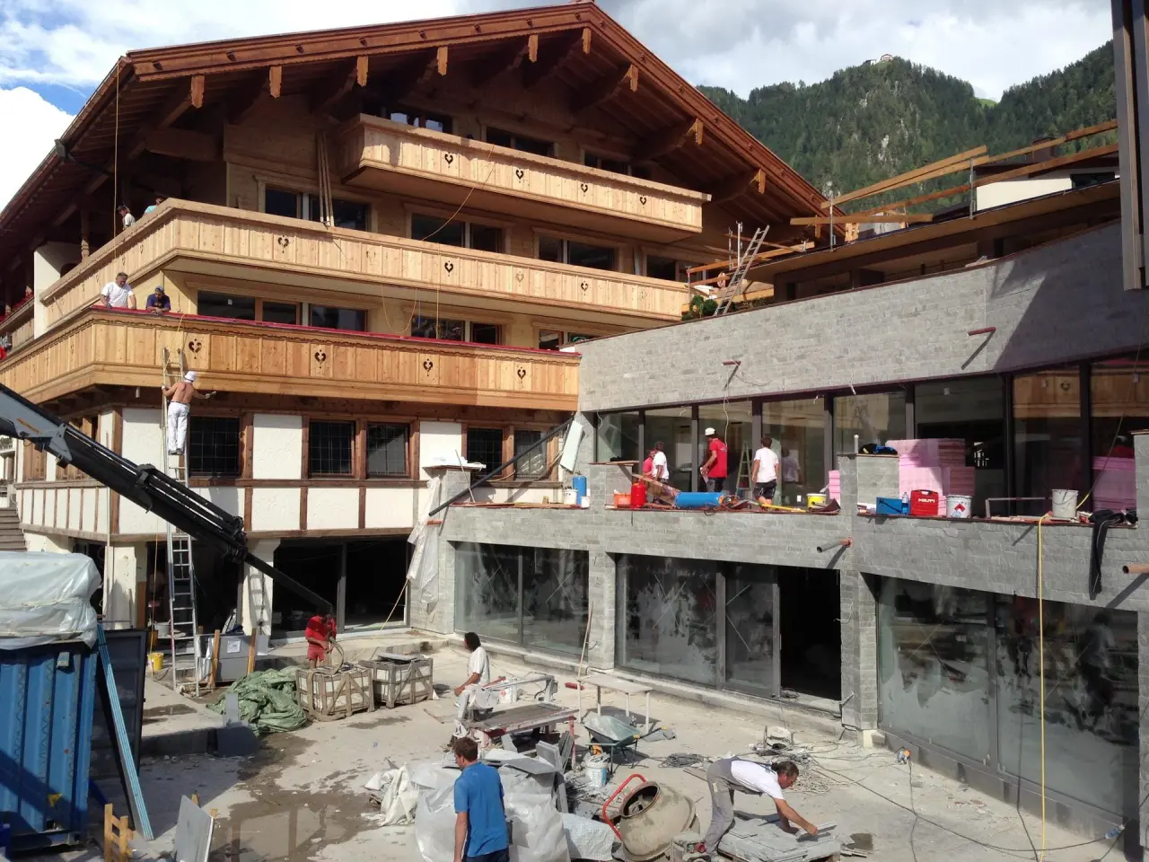 Baustelle des ElisabethHotel mit traditioneller Holzarchitektur und modernen Anbauten vor Bergkulisse.