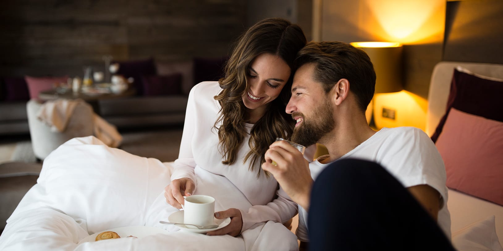 ElisabethHotel in Mayrhofen – Glückliches Paar genießt Kaffee im komfortablen Hotelzimmer | Wellnesshotel Zillertal