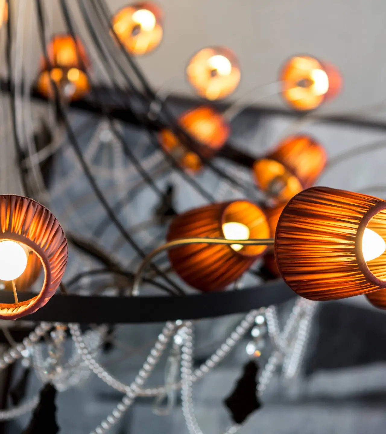 Nahaufnahme einer eleganten Deckenleuchte mit warm leuchtenden Lampenschirmen und dekorativen Elementen im DAS KRONTHALER****S.