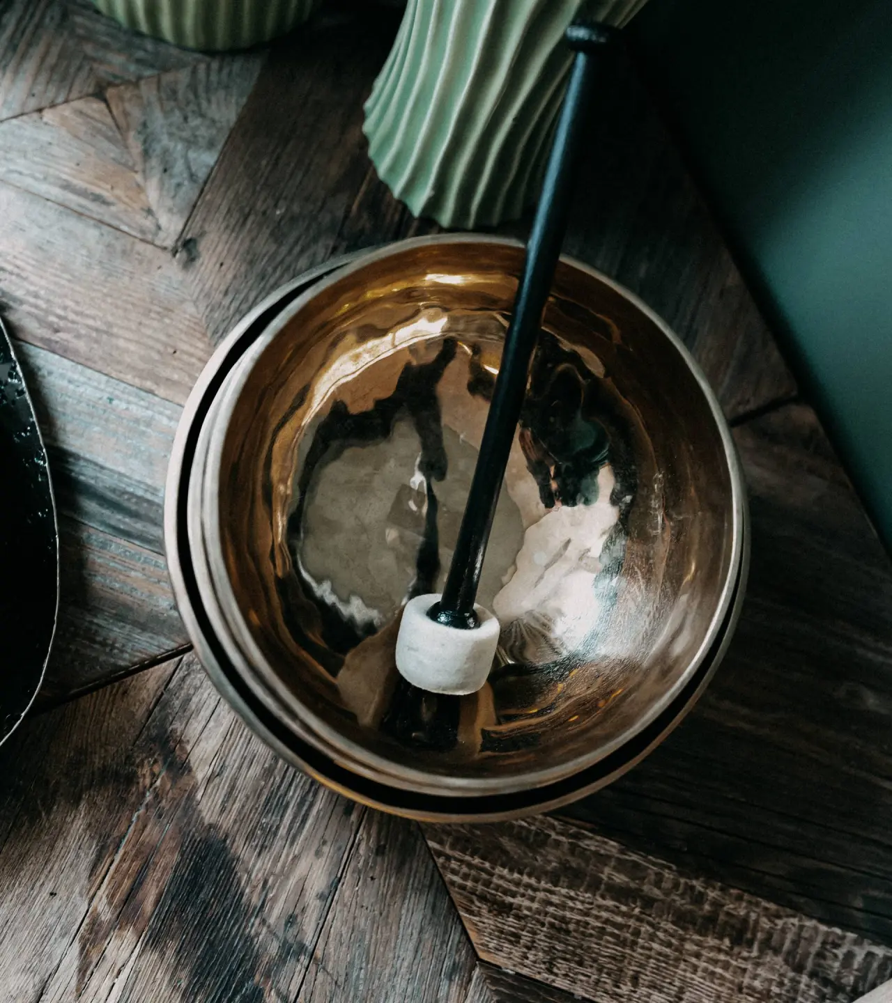 Klangschale mit Klöppel auf rustikalem Holztisch im Wellnessbereich von DAS KRONTHALER****S.