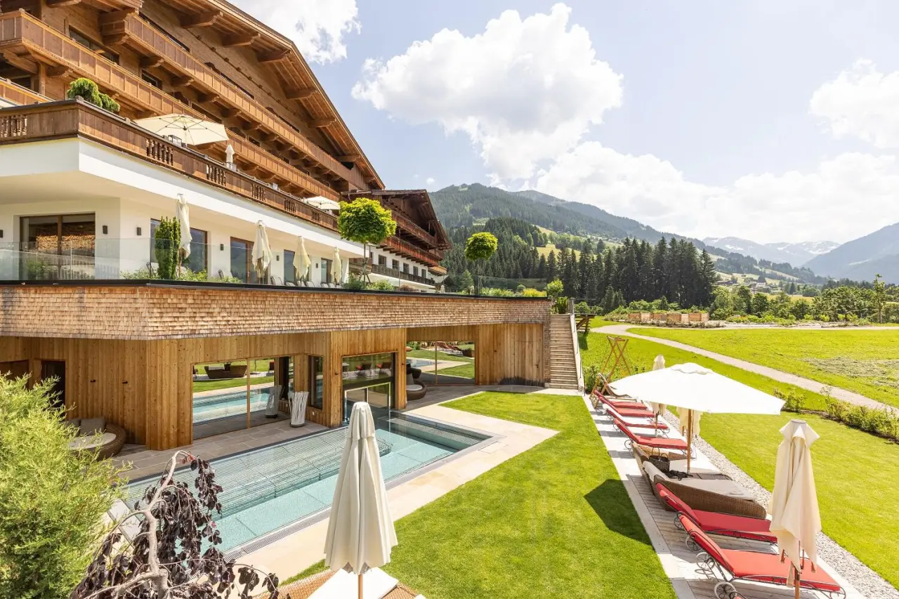 Aussenansicht des Alpbacherhof****s Mountain & Spa Resort mit Pool, Liegewiese und Alpenpanorama.