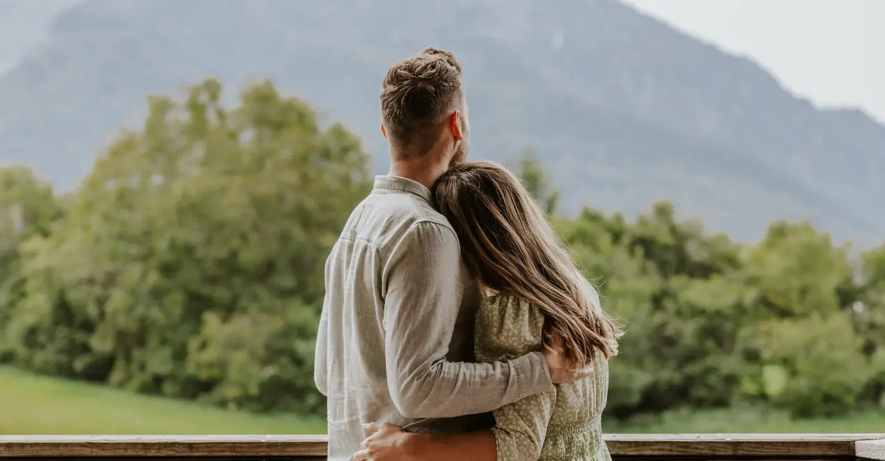 Paar genießt den Bergblick vom Balkon des Klosterhof - Alpine Hideaway & Spa
