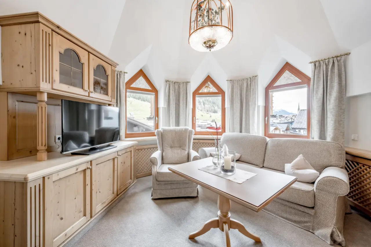 Gemütlicher Wohnbereich einer Suite im Hotel Trofana Royal mit traditionellen Holzmöbeln und Bergblick.