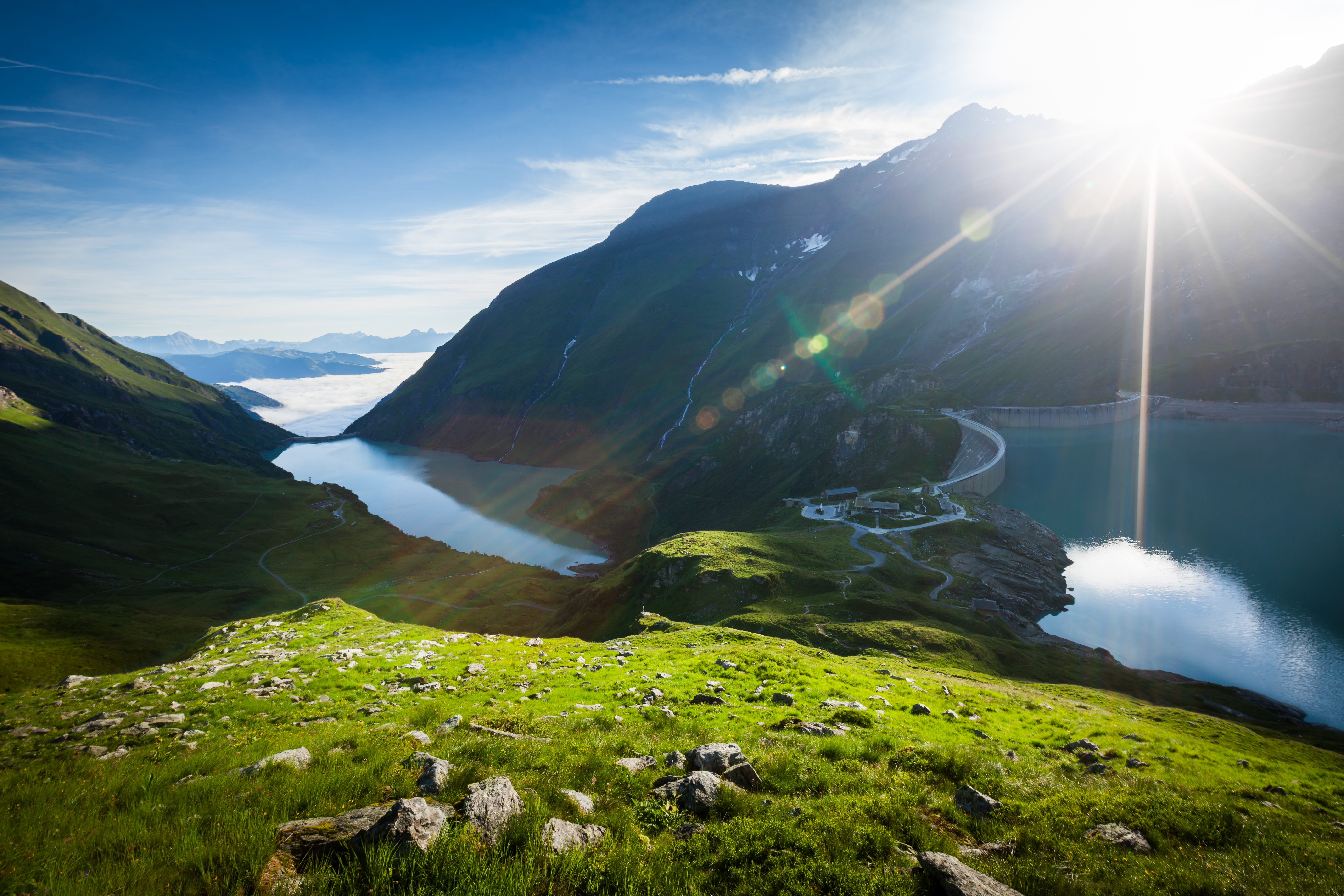 Das Alpenhaus Kaprun in Kaprun – Beeindruckende Berglandschaft mit Stausee und Sonnenstrahlen | Wellnesshotel Salzburger Land