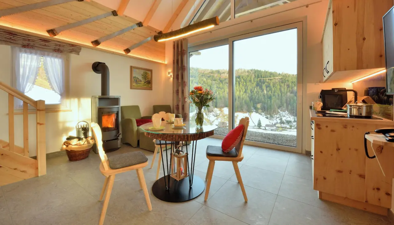 Gemütliches Apartment im Hotel Rößle mit Kamin, Essbereich, Küchenzeile und Bergblick.