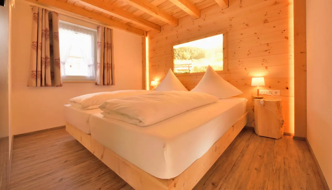 Gemütliches Doppelzimmer im alpinen Stil mit Holzelementen und indirekter Beleuchtung im Hotel Rößle.