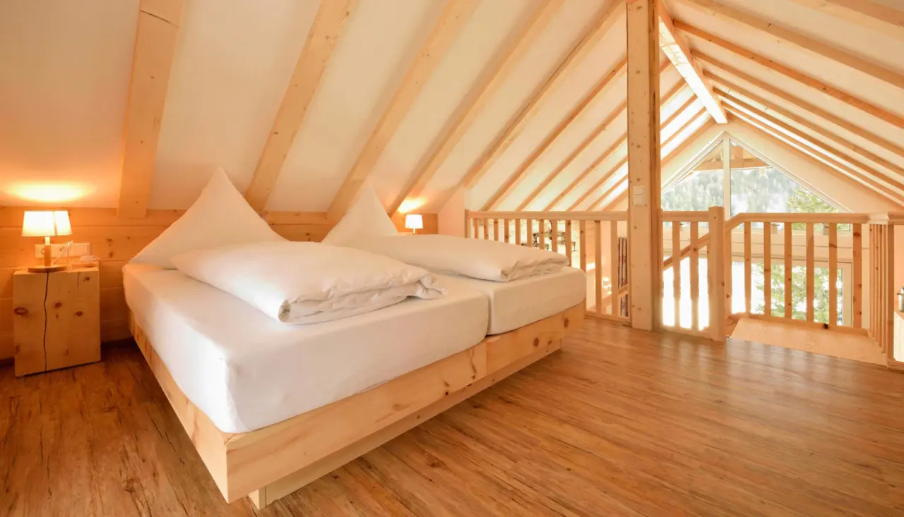 Gemütliches Doppelzimmer im Dachgeschoss des Hotel Rößle mit Holzbalken und Blick ins Grüne.