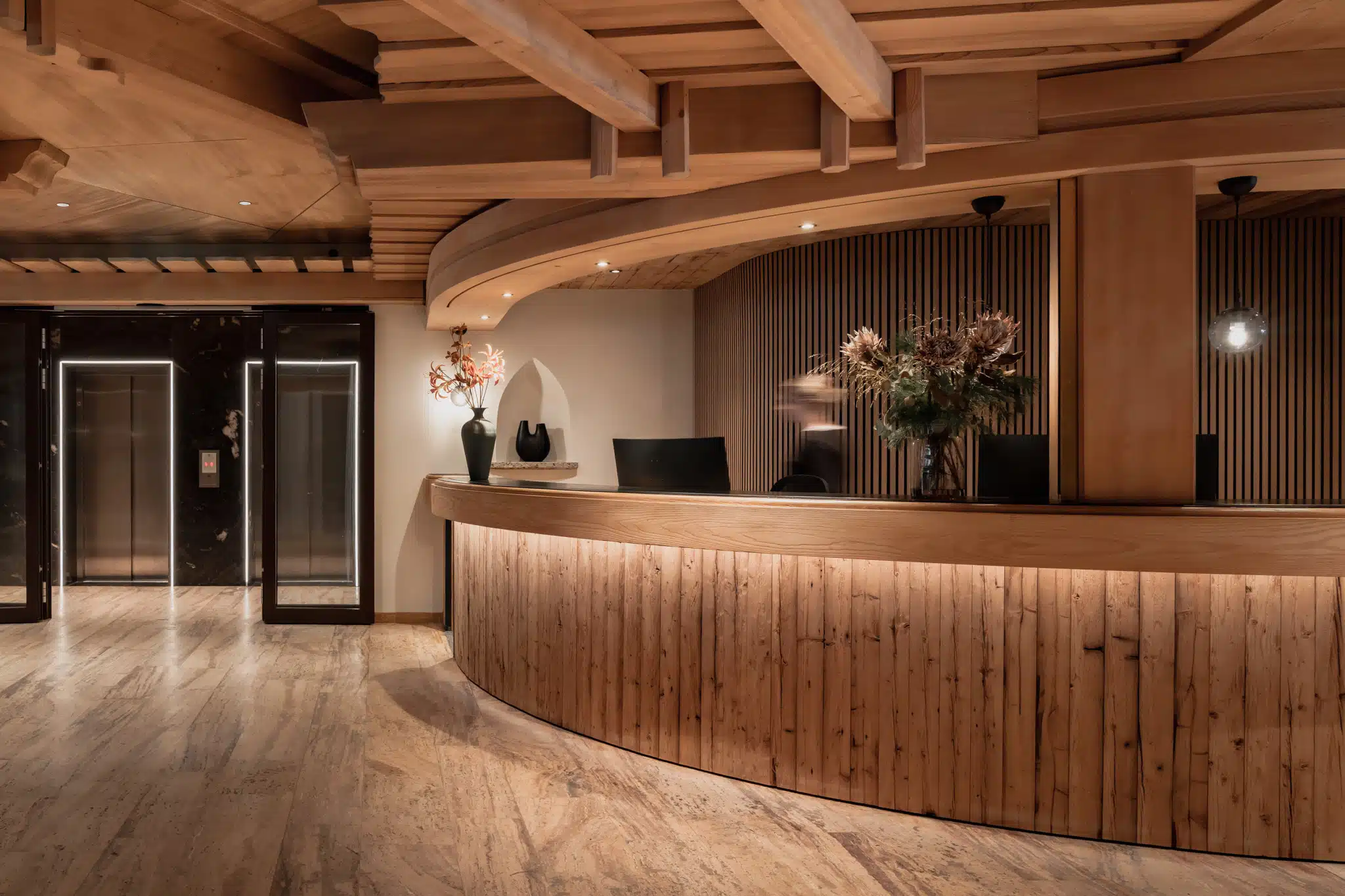 Hotel Alpenrose in Elbigenalp – Moderne Rezeption mit Holzelementen und indirekter Beleuchtung | Wellnesshotel Lechtal