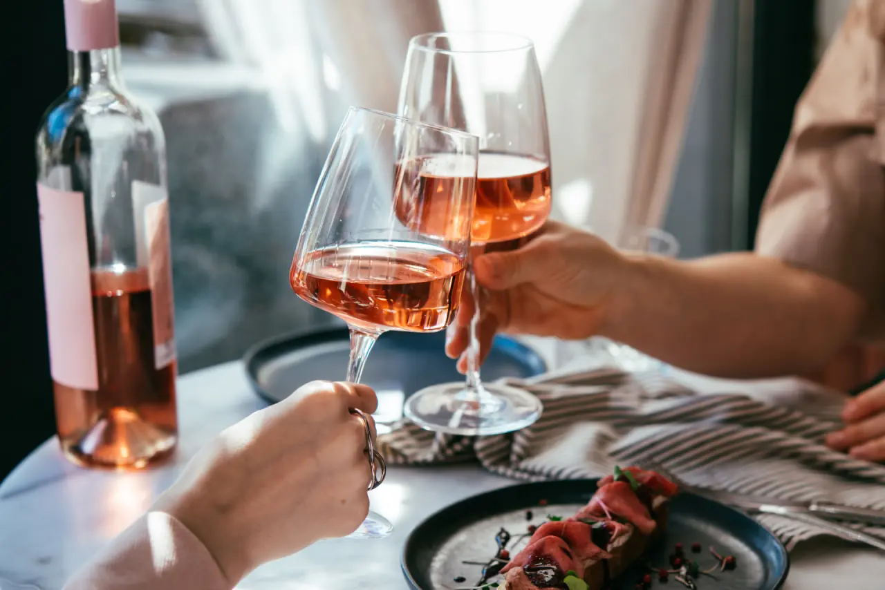 Hotel DIE POST in Bad Kleinkirchheim – Zwei Personen stoßen mit Roséwein an | Wellnesshotel Kärnten