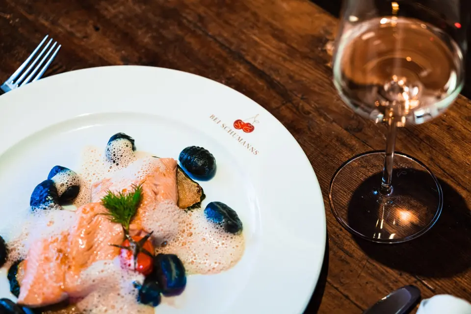 Exquisiter Lachs mit Schaum und Gnocchi im Restaurant des Hotel BEI SCHUMANN, dazu ein Glas Weißwein.