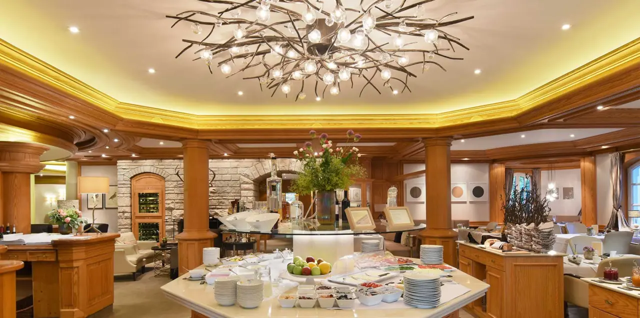 Elegantes Frühstücksbuffet im Restaurant des Landhaus Wachtelhof mit stilvoller Holzvertäfelung und Kronleuchter.