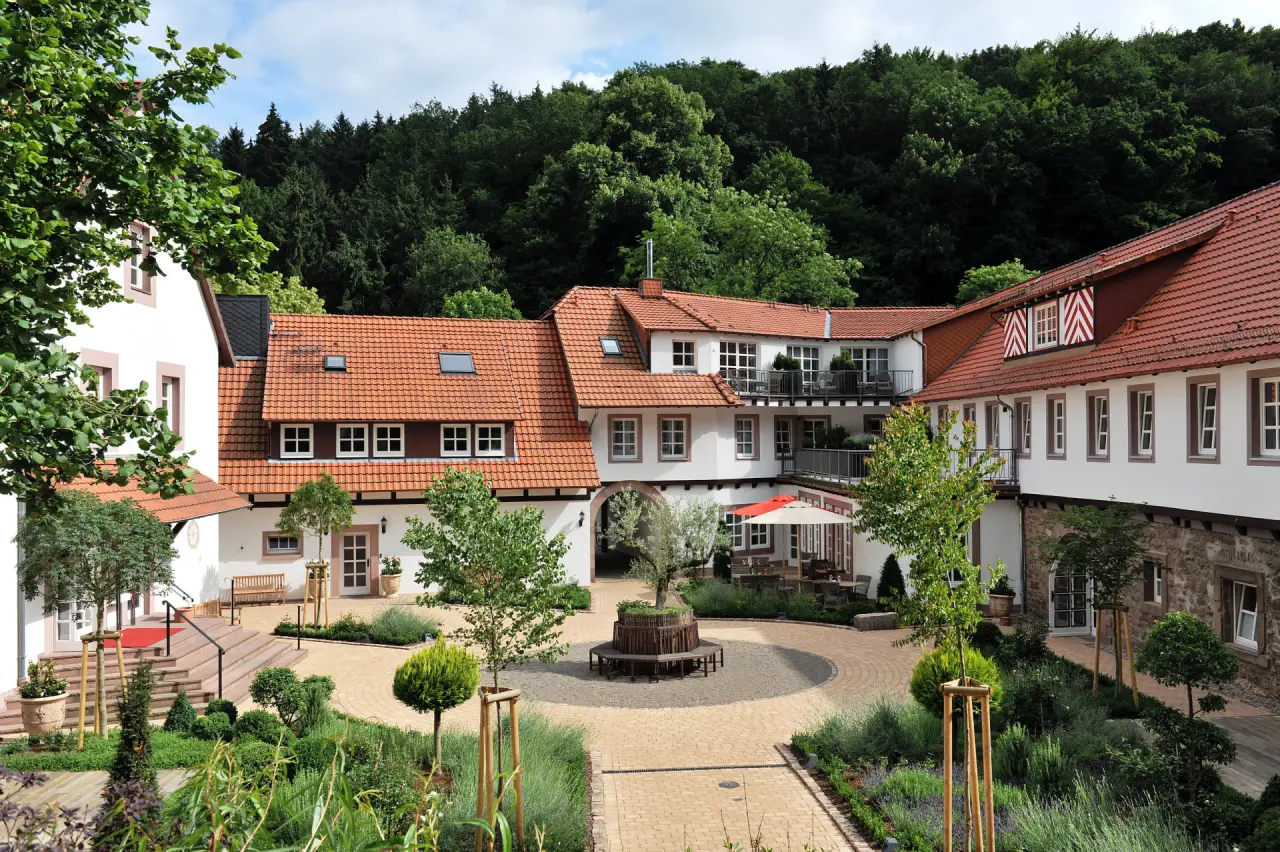 Malerischer Innenhof des Relais & Châteaux Hardenberg BurgHotel mit traditioneller Architektur und grüner Gartenanlage.