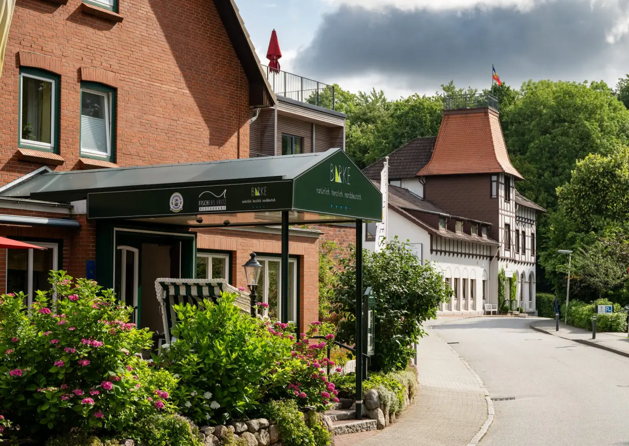 Aussenansicht des Hotel Birke mit Restaurant Fischers Fritz, blühenden Hortensien und Strandkorb am Eingang.
