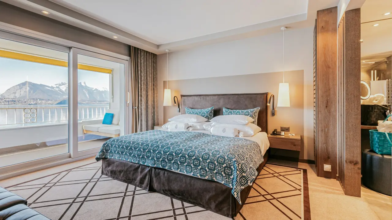 Luxuriöses Hotelzimmer im BEATUS Wellness- & Spa-Hotel mit Seeblick und Alpenpanorama vom Balkon.