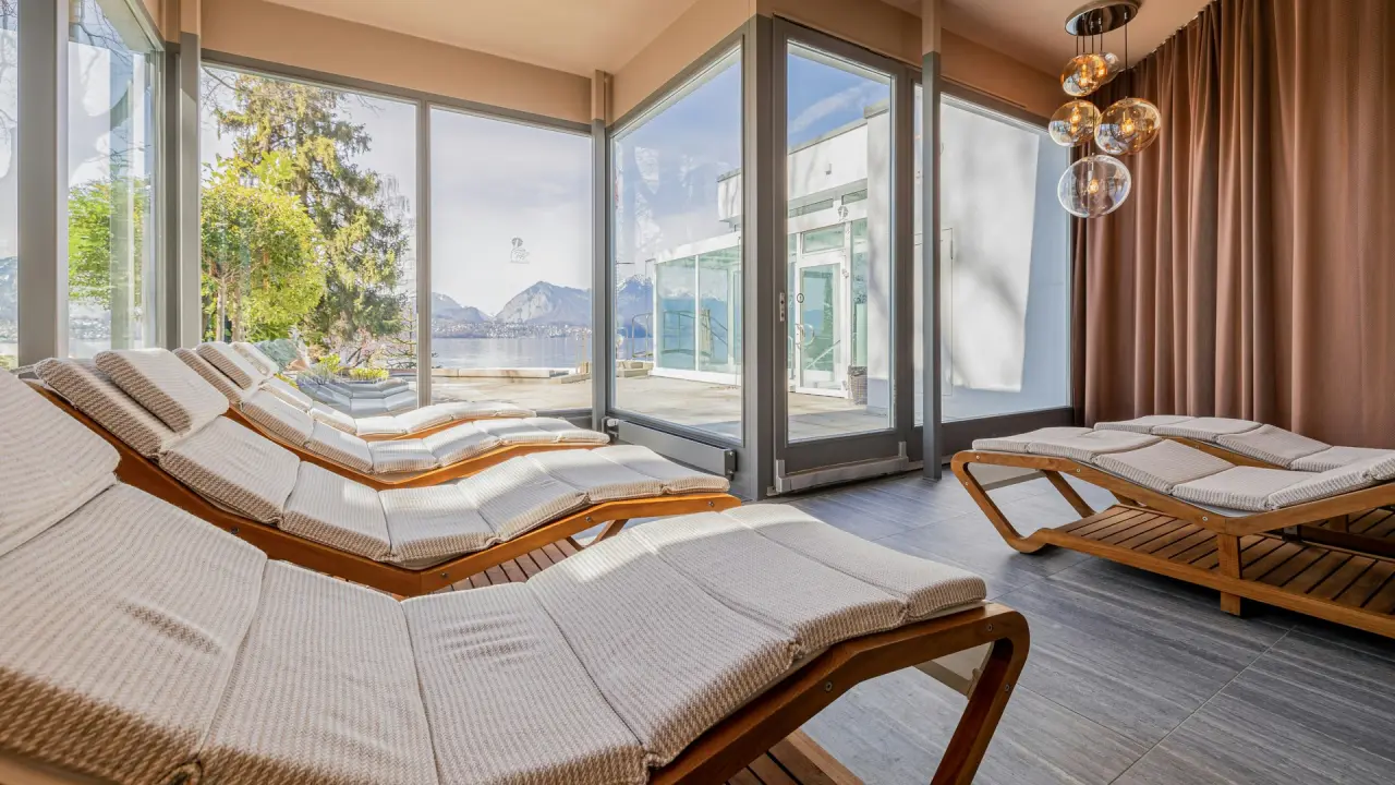 Entspannungsbereich mit bequemen Liegen und Panoramablick auf den Thunersee im BEATUS Wellness- & Spa-Hotel.