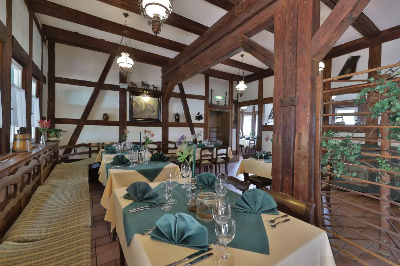 Rustikales Restaurant im Fachwerkstil mit festlich gedeckten Tischen im Hotel Hammermühle.