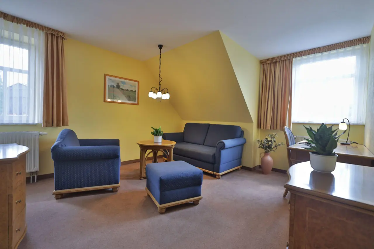 Geräumiges Hotelzimmer mit gemütlichem Sitzbereich und Schreibtisch im Hotel Hammermühle