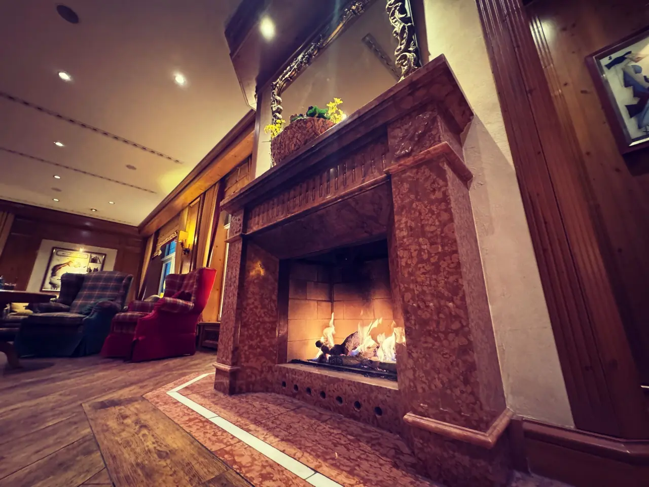 Gemütlicher Kamin in der Lobby des Revita Wellnesshotels mit bequemen Sesseln im Hintergrund.