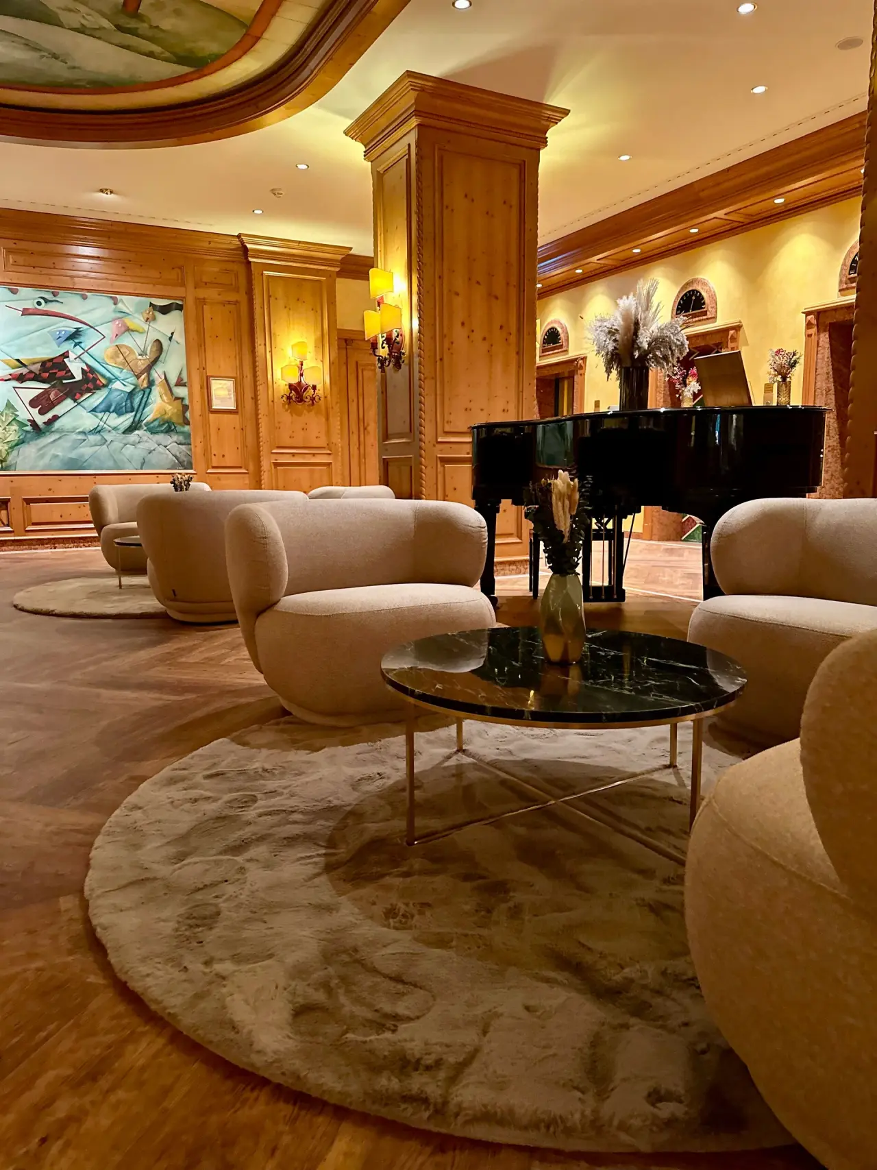 Einladende Hotellobby des Revita Wellnesshotels mit bequemen Sesseln, Holzelementen und Flügel für entspannte Momente.